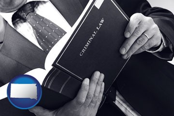 an attorney reading a criminal law book - with South Dakota icon